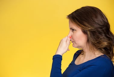 Side view profile portrait middle aged woman covers pinches her nose with hand looks with disgust, something stinks bad smell situation isolated yellow background. Human face expression body language-1